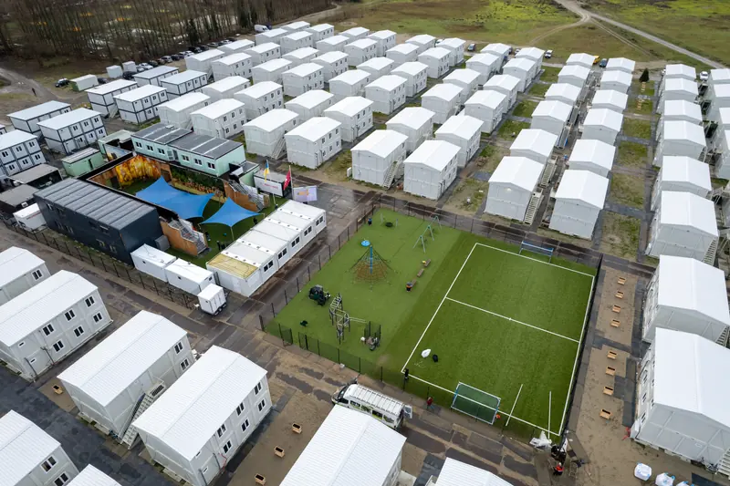 Luchtfoto met speelplein en kunstgrasveld tussen de woonblokken