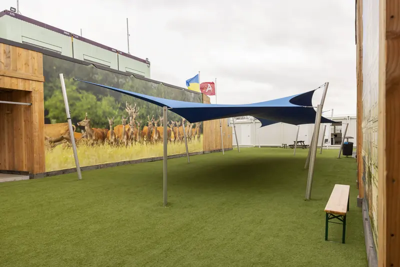 Speelplaats met kunstgras, zonnezeil en bank